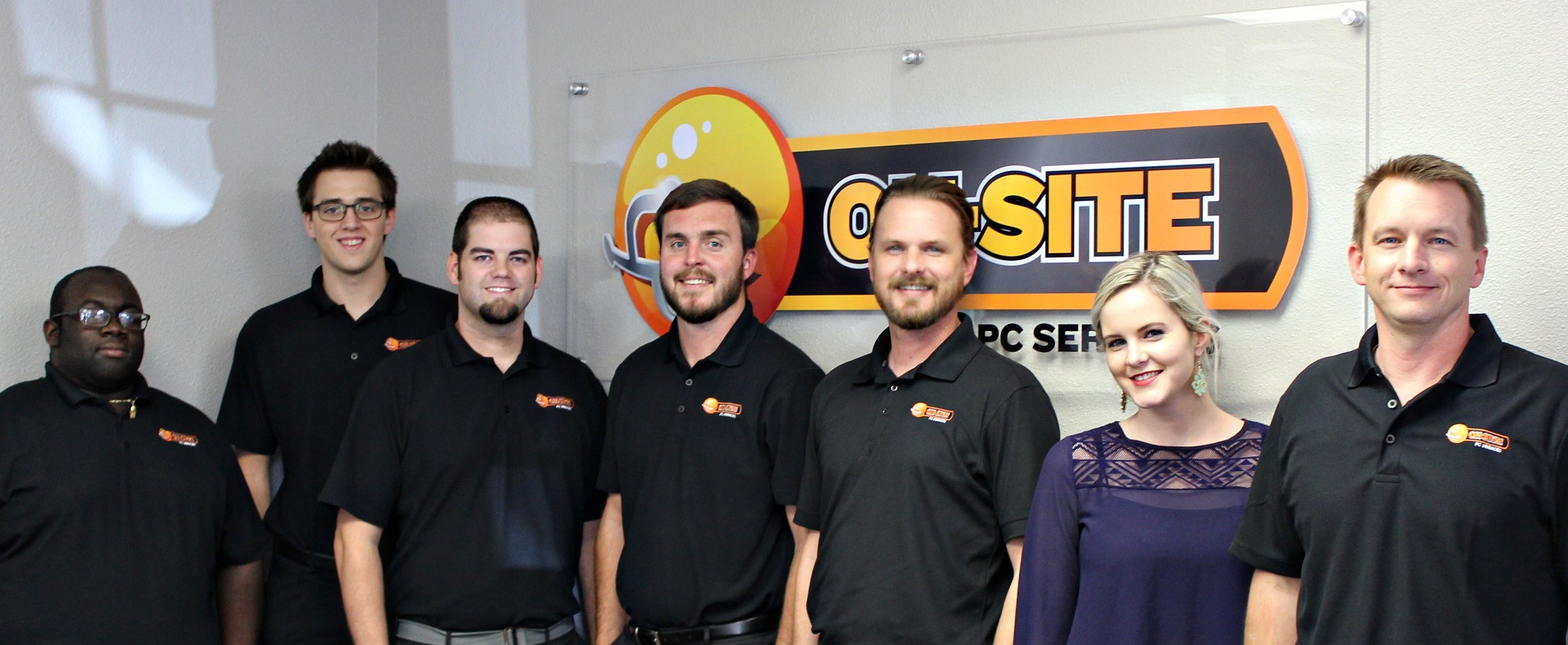 Seven members of the OSIT team standing together at the company office in 2016