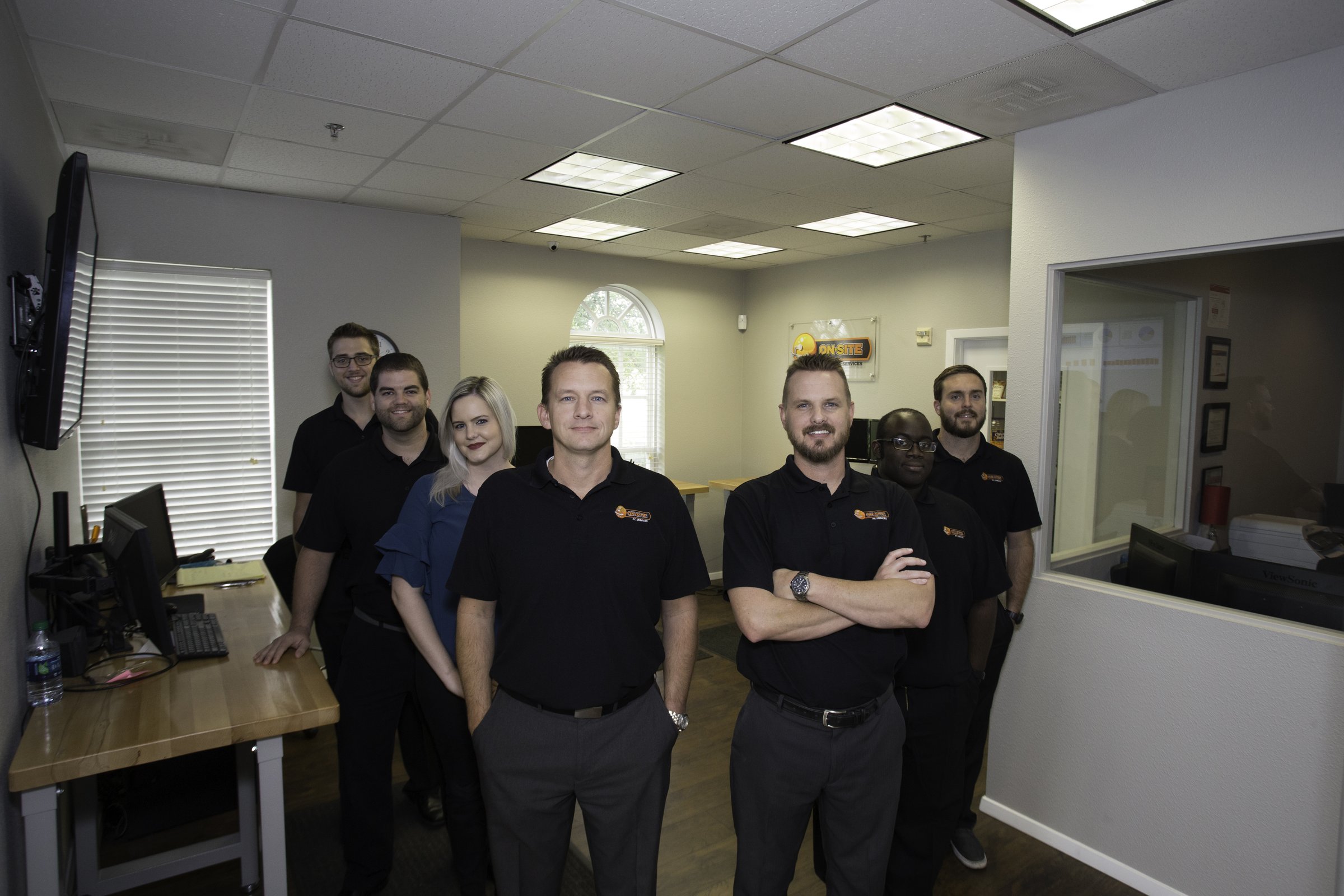 An earlier OSIT team standing together in the company office